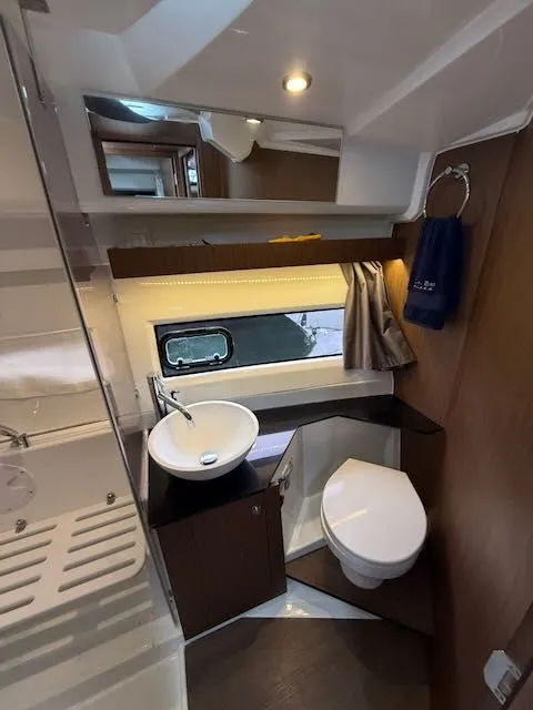 Slide: The Image of The image shows a modern boat bathroom with a sink, toilet, and mirror. - 26