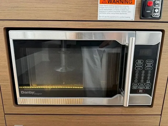 Slide: The Image of A microwave oven is built into a wooden panel, with a warning sign above. - 15