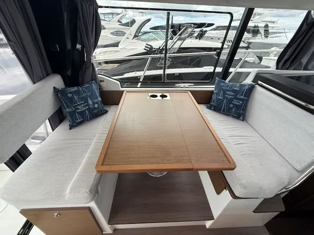 Slide: The Image of Interior view of a Jeanneau NC 1095 with a wooden table and white benches. - 7