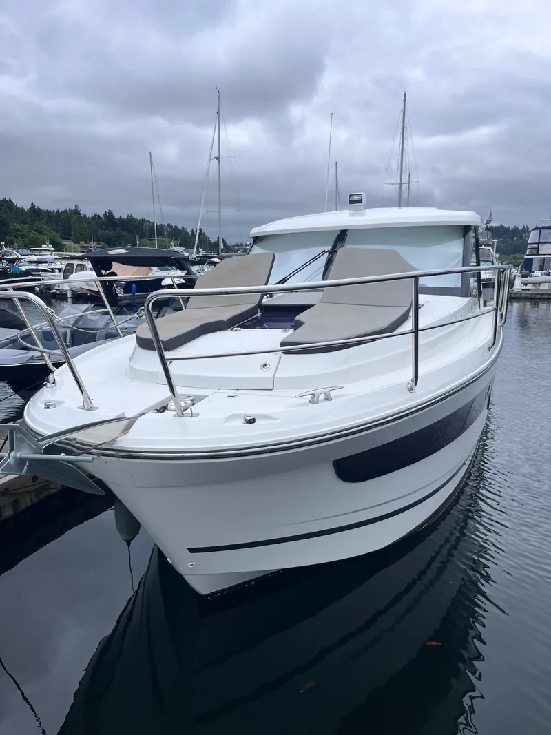 Slide: The Image of A 2021 Jeanneau NC 1095 docked in a marina. It features a modern design with sunbathing areas. - 39
