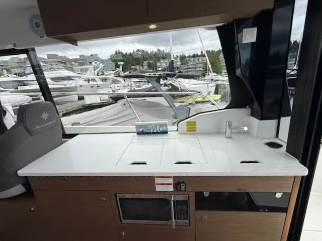 Slide: The Image of Interior of a Jeanneau NC 1095 with modern kitchen and marina view. - 11