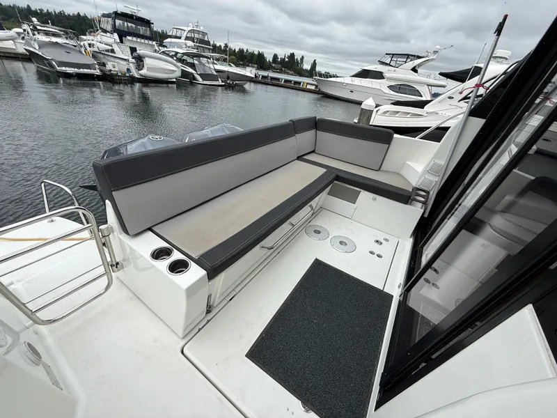 Slide: The Image of The image shows the stern of a 2021 Jeanneau NC 1095 with gray seating cushions. - 47