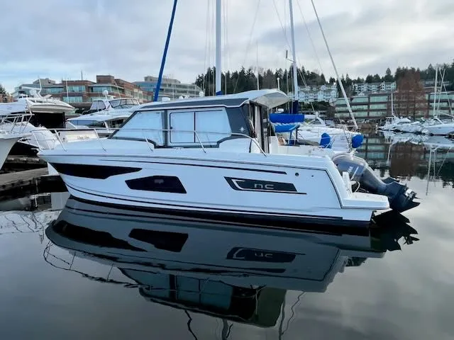 Slide: The Image of A 2021 Jeanneau NC 1095 is calmly docked in a marina. - 1
