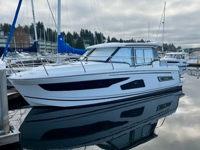 The Image of A 2021 Jeanneau NC 1095 boat is calmly docked on the water. - 0