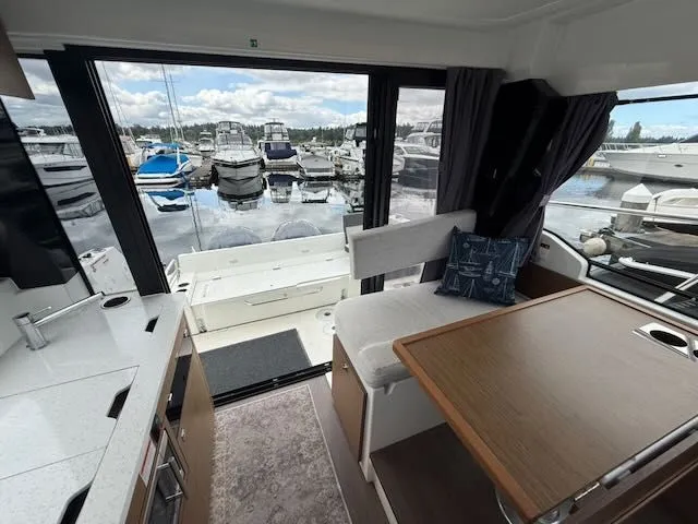 Slide: The Image of Interior of a Jeanneau NC 1095 with a view of the marina. - 6