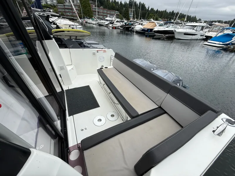 Slide: The Image of The image shows the stern of a 2021 Jeanneau NC 1095 docked in a marina. - 48