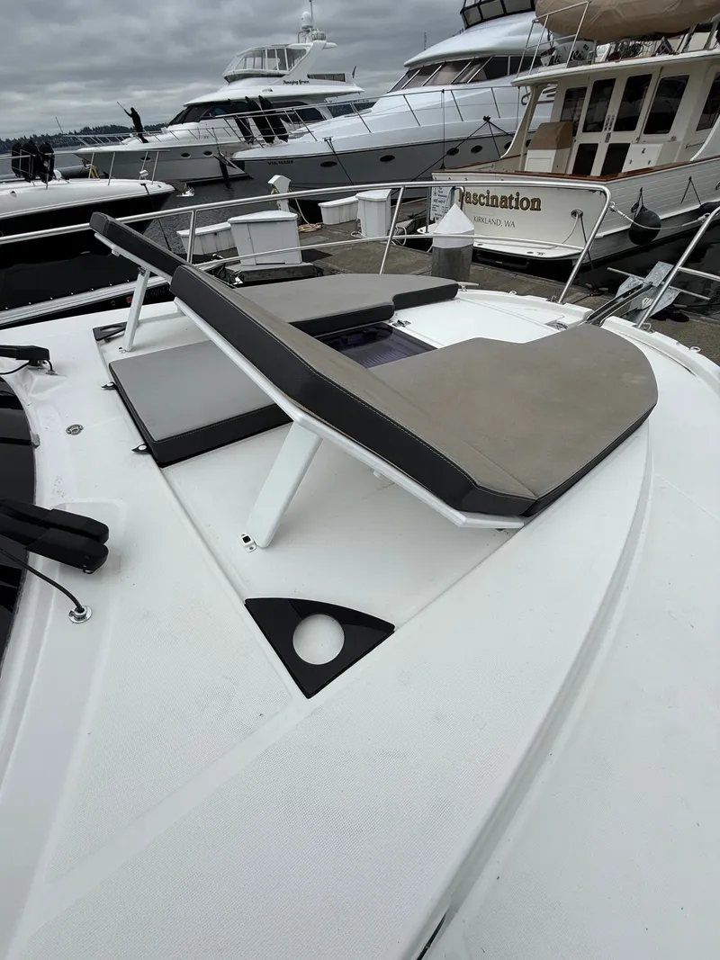 Slide: The Image of A sun deck on a 2021 Jeanneau NC 1095, surrounded by other boats in the harbor. - 44