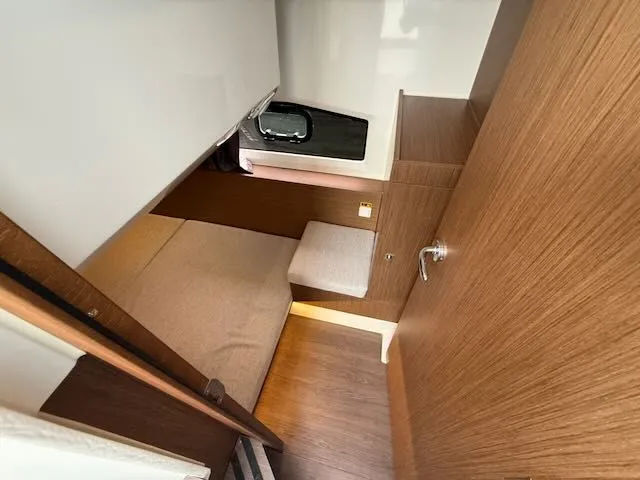 Slide: The Image of Interior of a 2021 Jeanneau NC 1095 with wooden walls and a bed. - 24