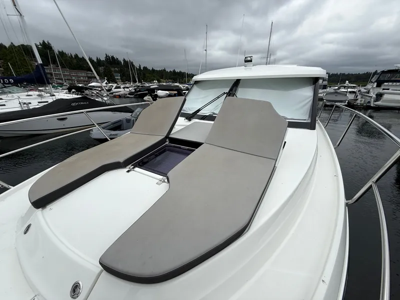 Slide: The Image of 2021 Jeanneau NC 1095 at a marina with gray sun loungers on the deck. - 42