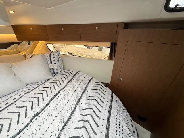 Slide: The Image of Interior of the Jeanneau NC 1095 with cozy bed and wooden cabinets. - 29