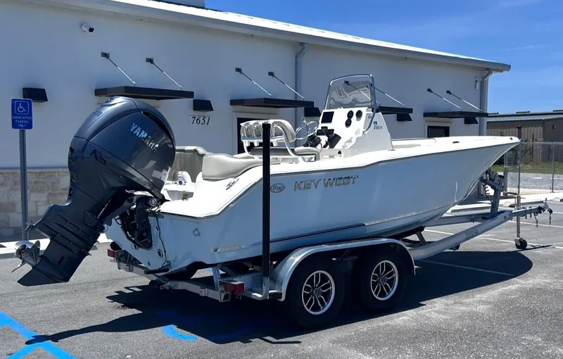 Slide: The Image of A Key West 203 FS boat on a trailer, parked in front of a building. - 3
