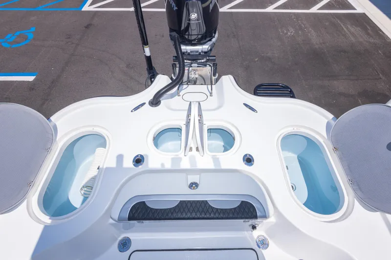 Slide: The Image of 2020 Turner Boatworks 2500 VS deck with storage compartments and motor, parked on asphalt. - 19