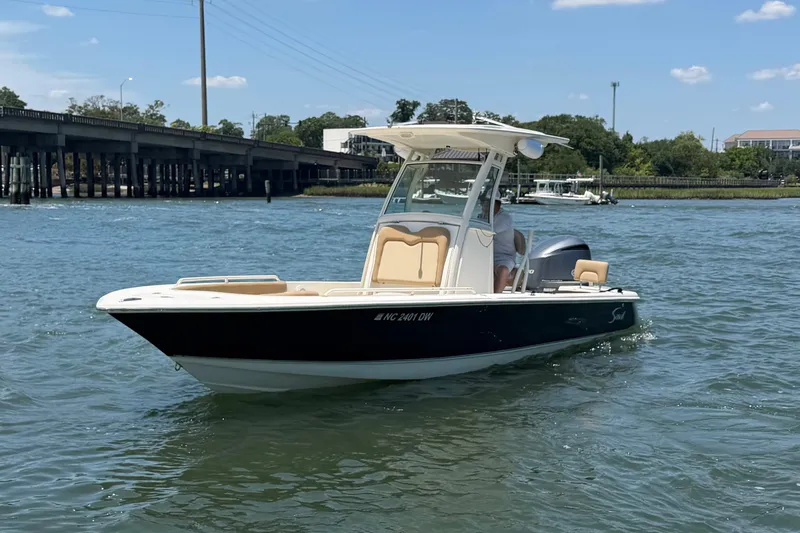 Slide: The Image of 2012 Scout 251 XS boat on water near a bridge under a clear sky. - 4