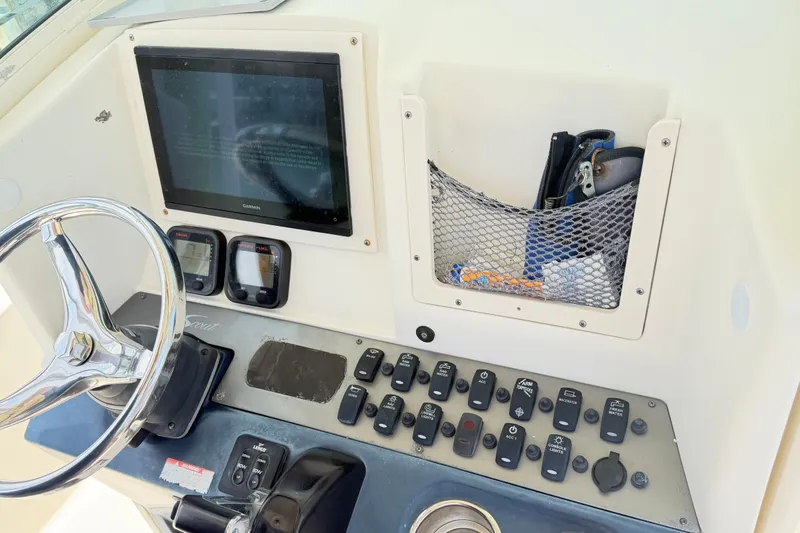 Slide: The Image of Control panel of a 2012 Scout 251 XS boat with steering wheel and electronic displays. - 7