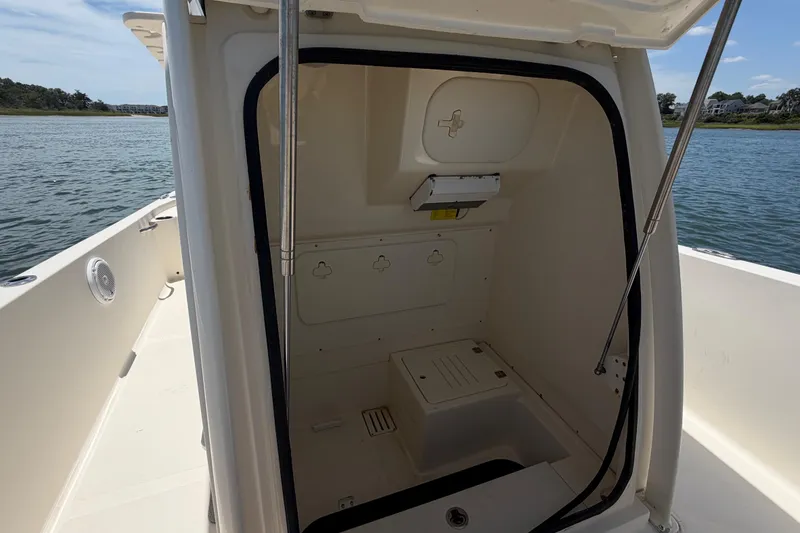 Slide: The Image of 2012 Scout 251 XS boat interior with open storage compartment on calm water. - 30
