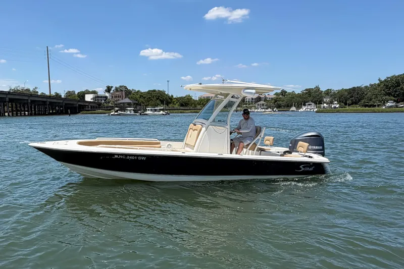 Slide: The Image of 2012 Scout 251 XS boat cruising on a sunny day with a clear blue sky. - 7