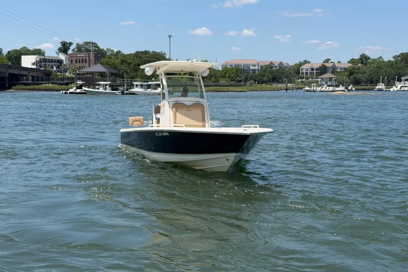 Slide: The Image of 2012 Scout 251 XS boat on calm water near a marina. - 8