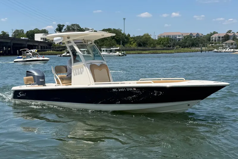 The Image of 2012 Scout 251 XS boat cruising on a sunny day in a scenic waterway. - 0