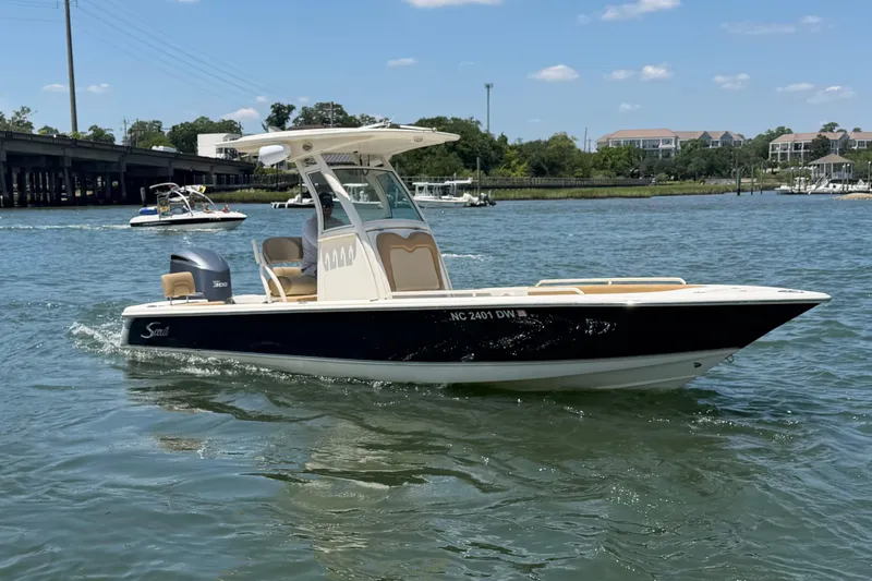 Slide: The Image of 2012 Scout 251 XS boat cruising on a sunny day in a scenic waterway. - 9