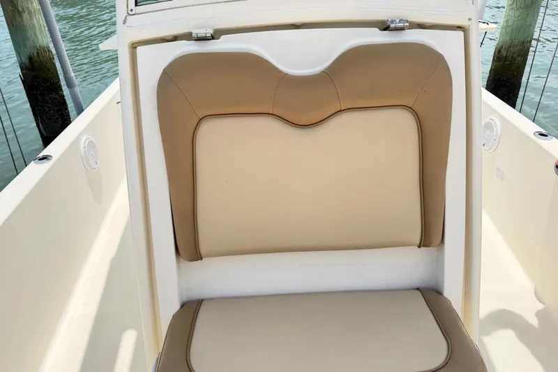 Slide: The Image of 2012 Scout 251 XS boat seat with beige upholstery, docked by water. - 4