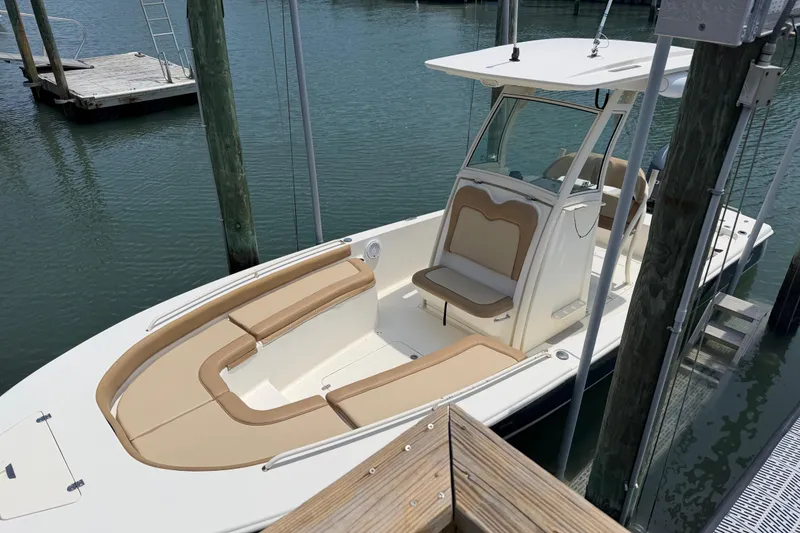Slide: The Image of 2012 Scout 251 XS boat docked, featuring tan seating and sleek design. - 10