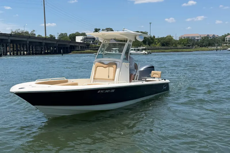 Slide: The Image of 2012 Scout 251 XS boat on water near a bridge under a clear sky. - 3