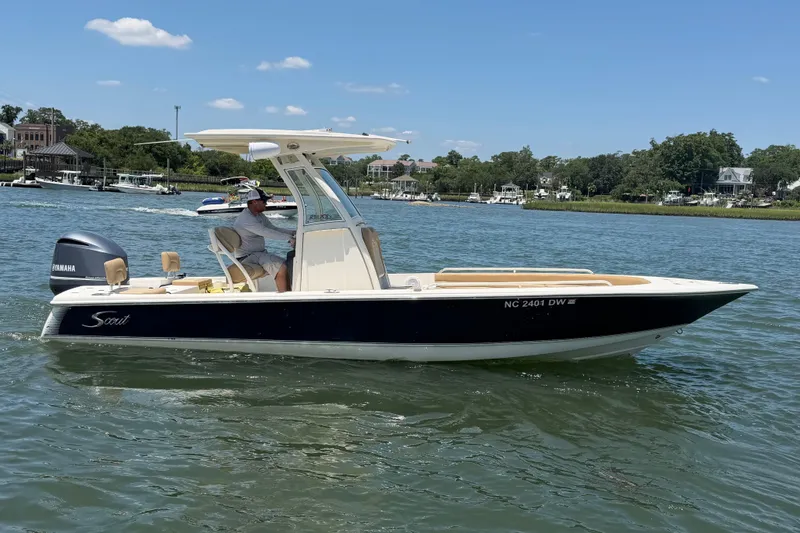 Slide: The Image of 2012 Scout 251 XS boat cruising on a sunny day in a scenic waterway. - 10