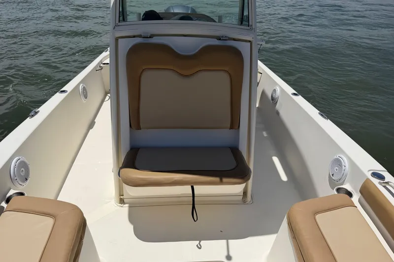 Slide: The Image of 2012 Scout 251 XS boat interior with tan seating and ocean backdrop. - 18