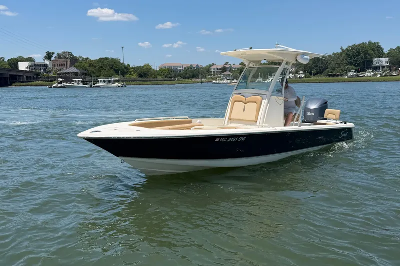 Slide: The Image of 2012 Scout 251 XS boat cruising on a sunny day in a scenic waterway. - 6