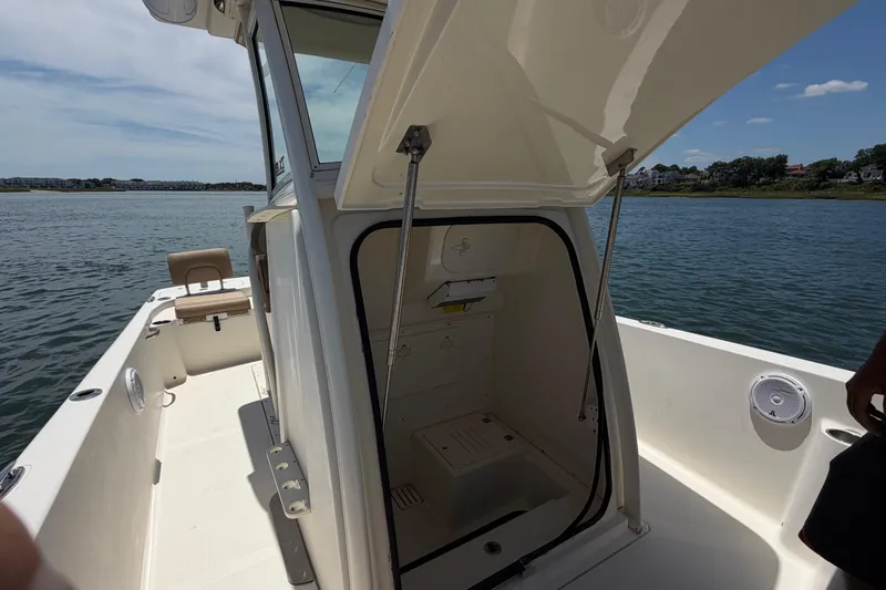 Slide: The Image of 2012 Scout 251 XS boat interior with open hatch, on calm water. - 29