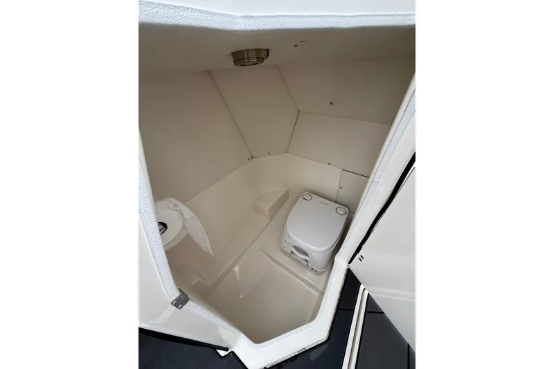Slide: The Image of 2021 Bayliner DX 2200 boat interior with compact marine toilet. - 10