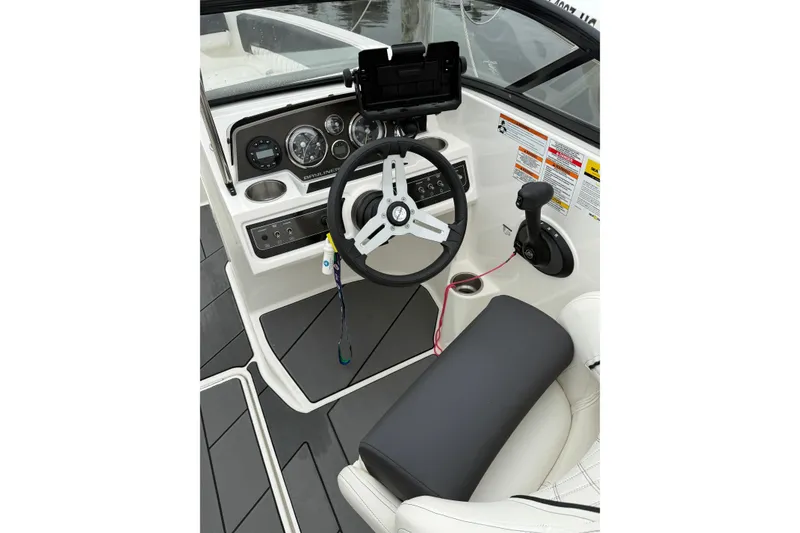 Slide: The Image of 2021 Bayliner DX 2200 boat cockpit with steering wheel and control panel. - 7