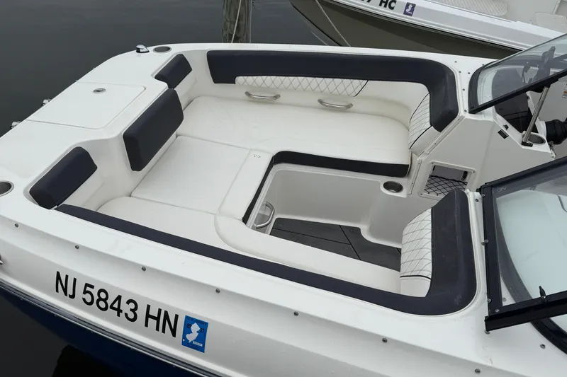Slide: The Image of 2021 Bayliner DX 2200 boat interior with cushioned seating and registration number NJ 5843 HN. - 4