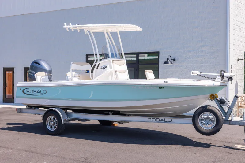 The Image of 2023 Robalo 206 Cayman boat on trailer, parked outside a building. - 0