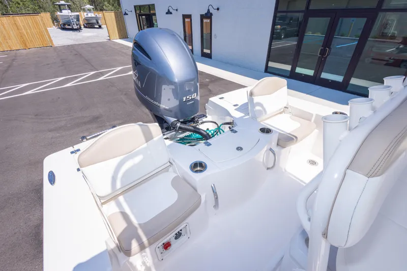 Slide: The Image of 2023 Robalo 206 Cayman boat with Yamaha 150 engine, docked near a modern building. - 30