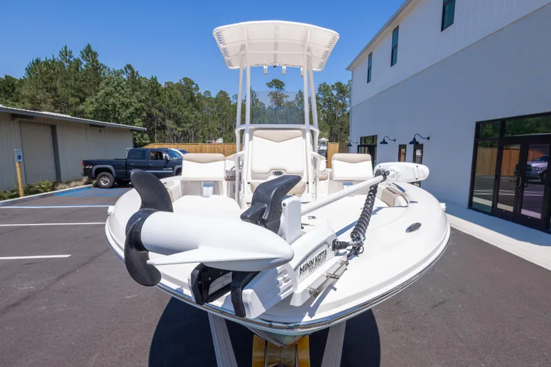 Slide: The Image of 2023 Robalo 206 Cayman boat with Minn Kota trolling motor, parked outdoors. - 9