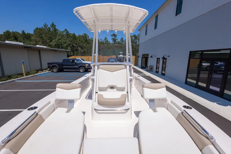 Slide: The Image of 2023 Robalo 206 Cayman boat interior with seating and T-top in a parking lot. - 23