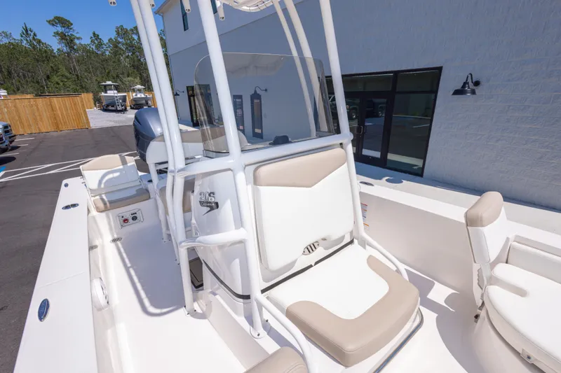 Slide: The Image of 2023 Robalo 206 Cayman boat interior with seating and console, parked outdoors. - 25