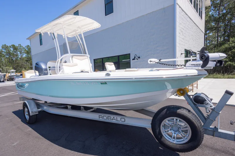 Slide: The Image of 2023 Robalo 206 Cayman boat on trailer, parked outside a building. - 1