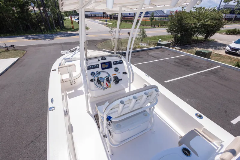 Slide: The Image of 2023 Robalo 206 Cayman boat interior with steering console and seating, parked outdoors. - 11