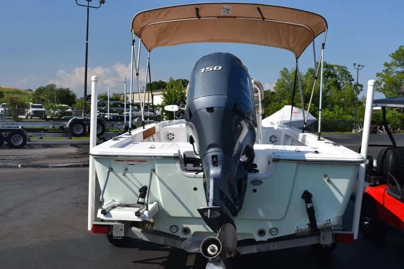 Slide: The Image of 2019 Sportsman Masters 207 Bay Boat with outboard motor and canopy in a parking lot. - 24