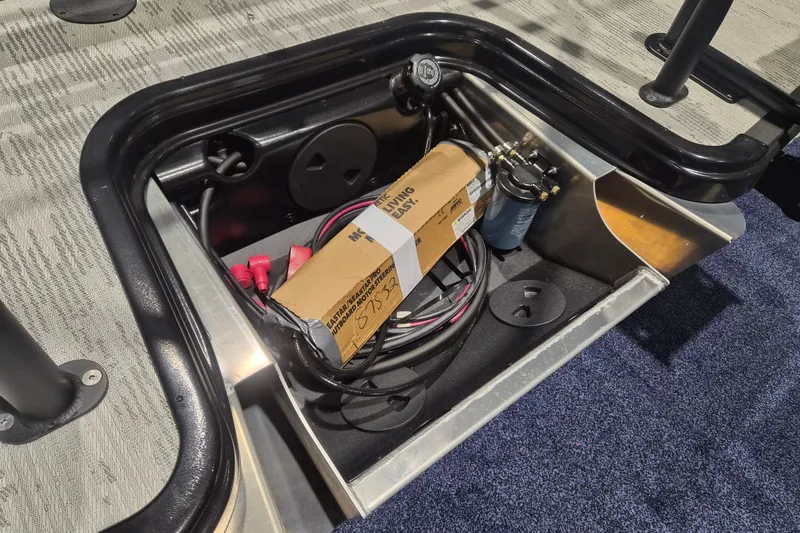 Slide: The Image of Storage compartment of 2026 Sylvan L3 SLZ boat with cables and a box. - 28