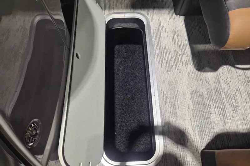 Slide: The Image of Open storage compartment in 2026 Sylvan L3 SLZ boat, featuring carpeted interior and sleek design. - 6