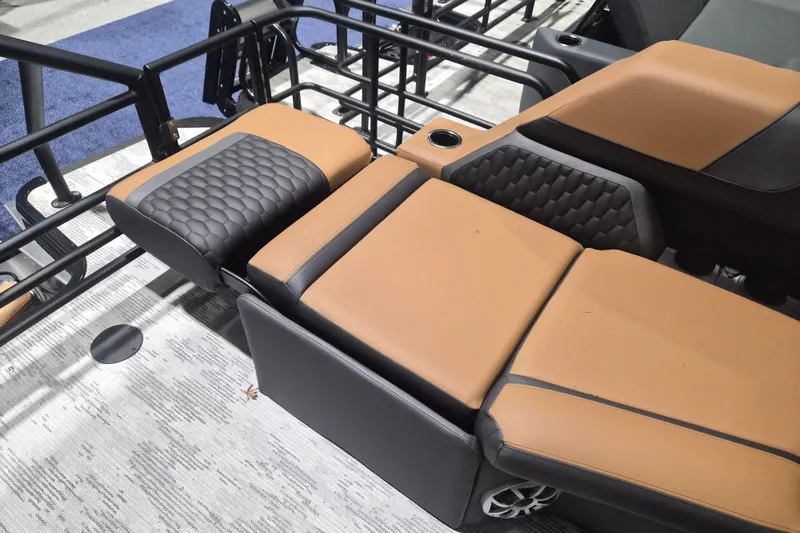Slide: The Image of 2026 Sylvan L3 SLZ boat seating with tan and black upholstery, featuring cup holders. - 21
