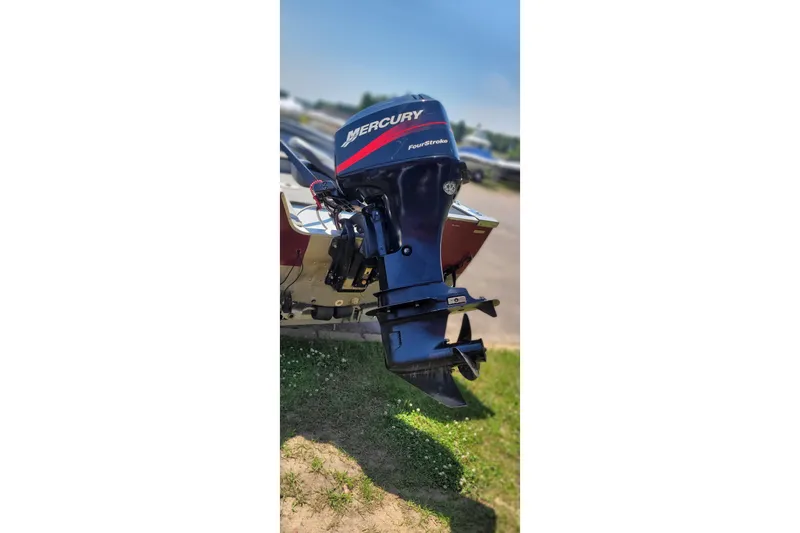 Slide: The Image of 1989 Lund 1600 Stinger boat with Mercury FourStroke outboard motor, parked on grass. - 8