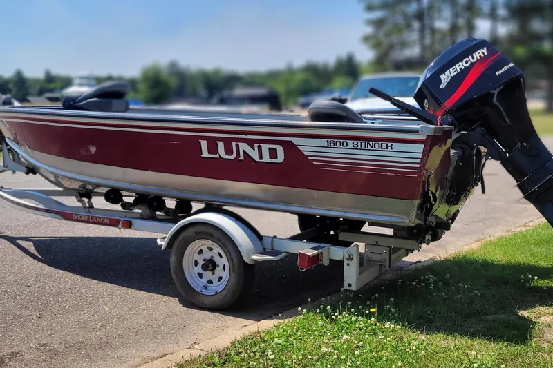 Slide: The Image of 1989 Lund 1600 Stinger boat on trailer with Mercury outboard motor. - 3