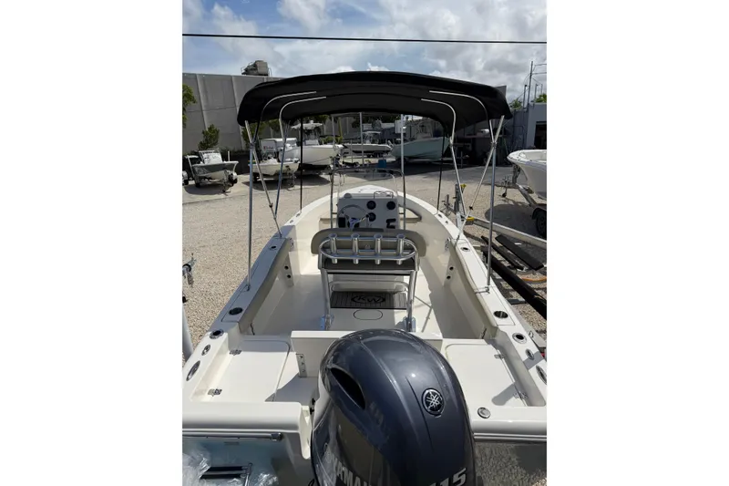 Slide: The Image of 2026 Key West 179 FS boat with canopy, parked in a marina under a cloudy sky. - 9