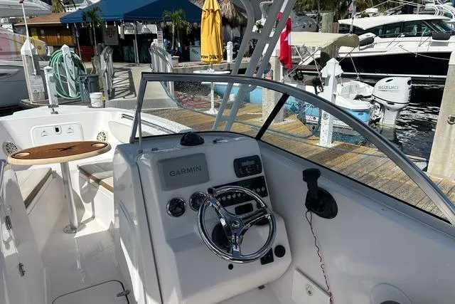 Slide: The Image of 2018 Pro-Line 23 Dual Console boat interior with Garmin navigation, docked at marina. - 7