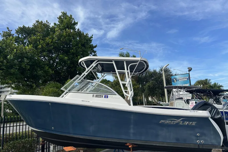 Slide: The Image of 2018 Pro-Line 23 Dual Console boat displayed outdoors under a clear sky. - 28
