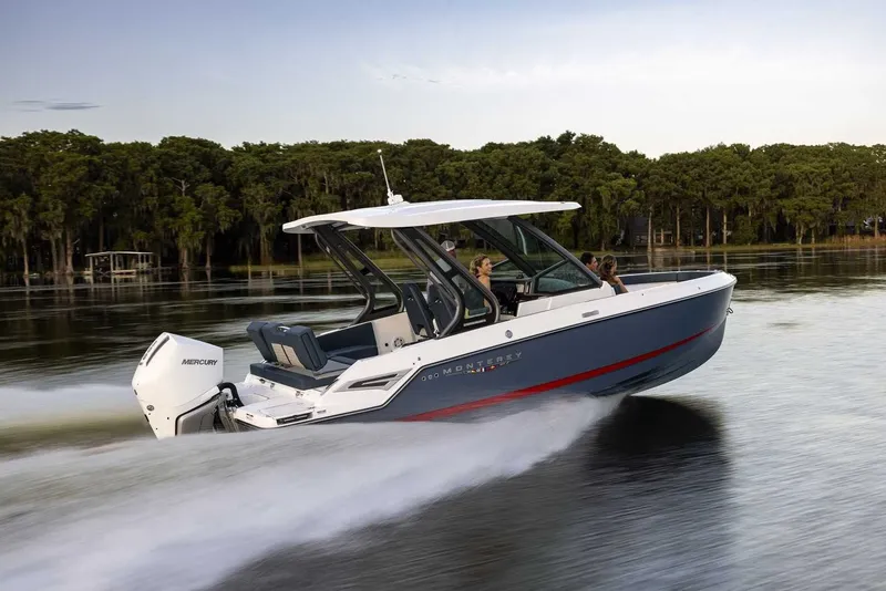 The Image of A modern motorboat speeds across calm water, surrounded by trees. - 0